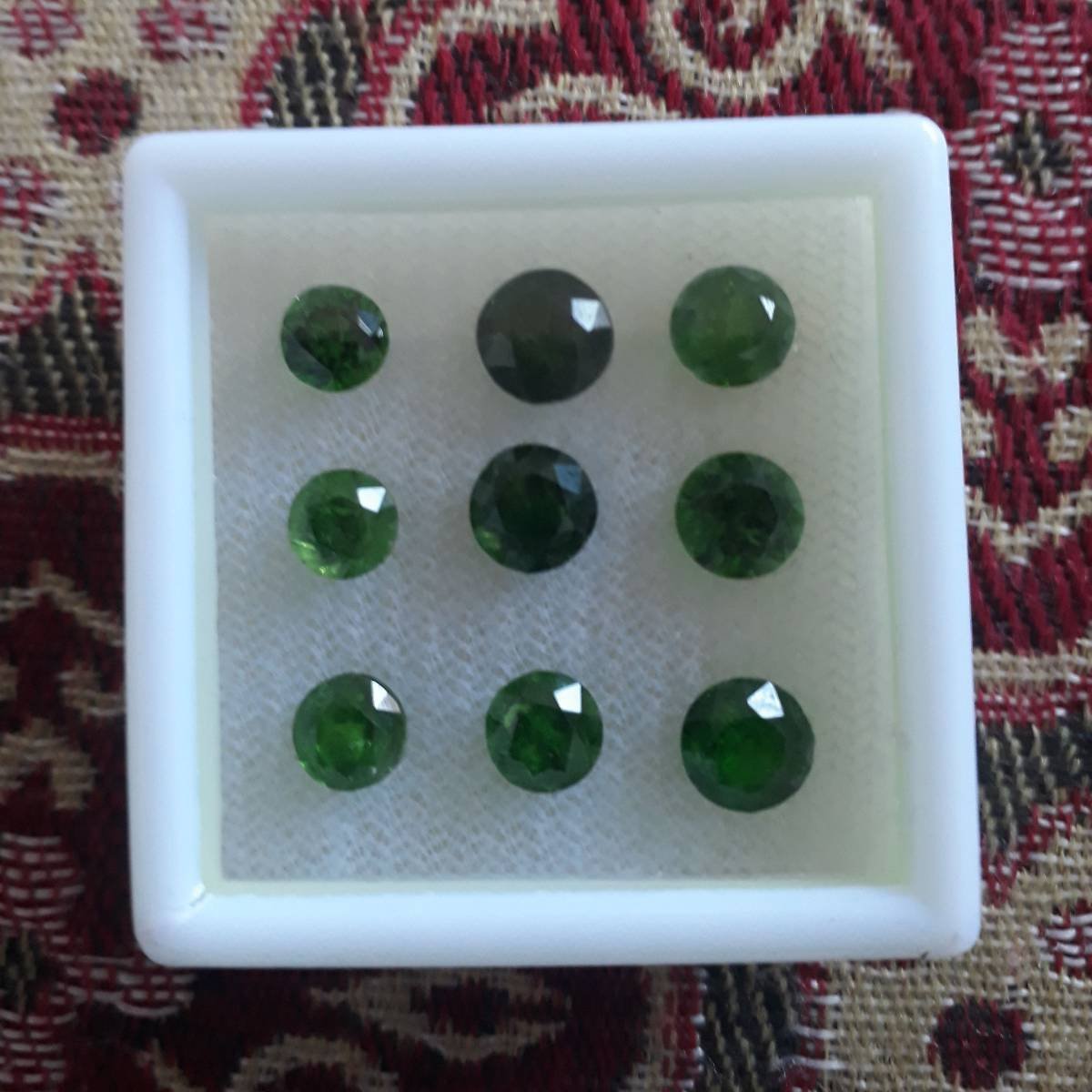 Nine green garnet gemstones.